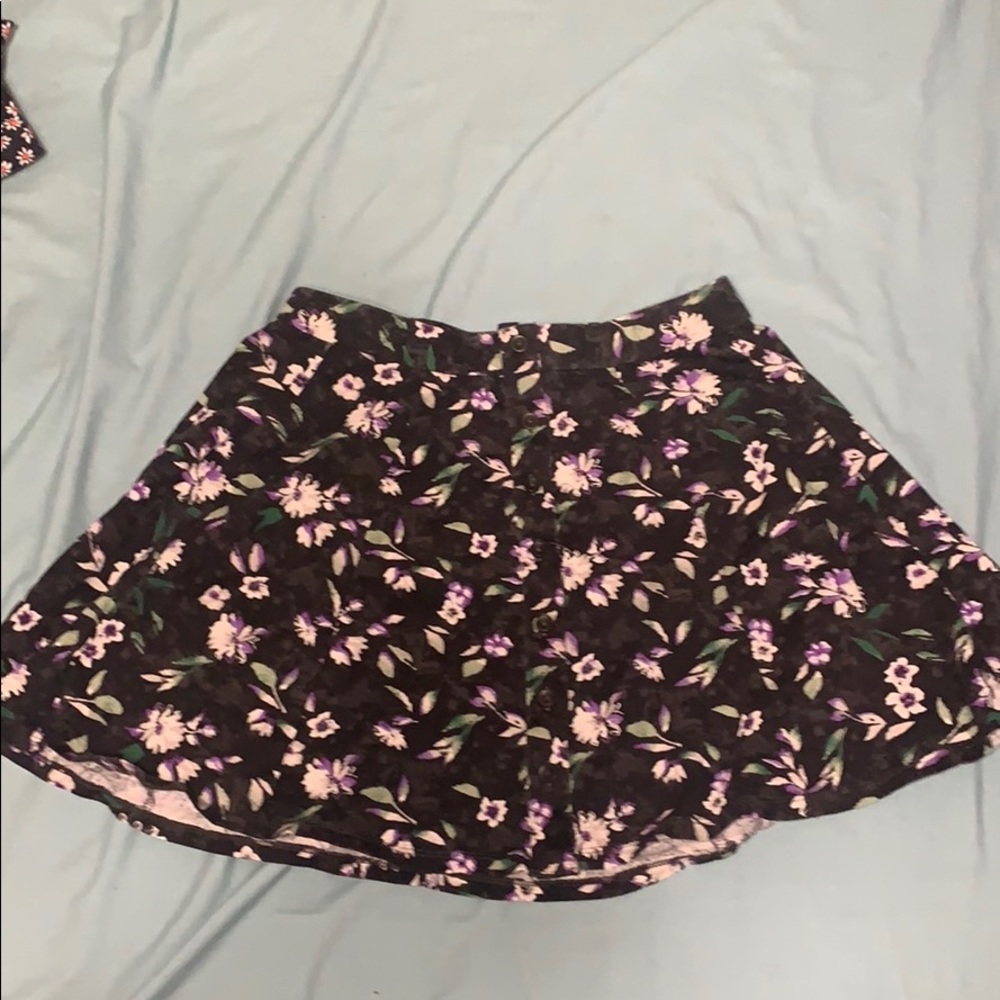 A black skirt with purple and white flowers on it.